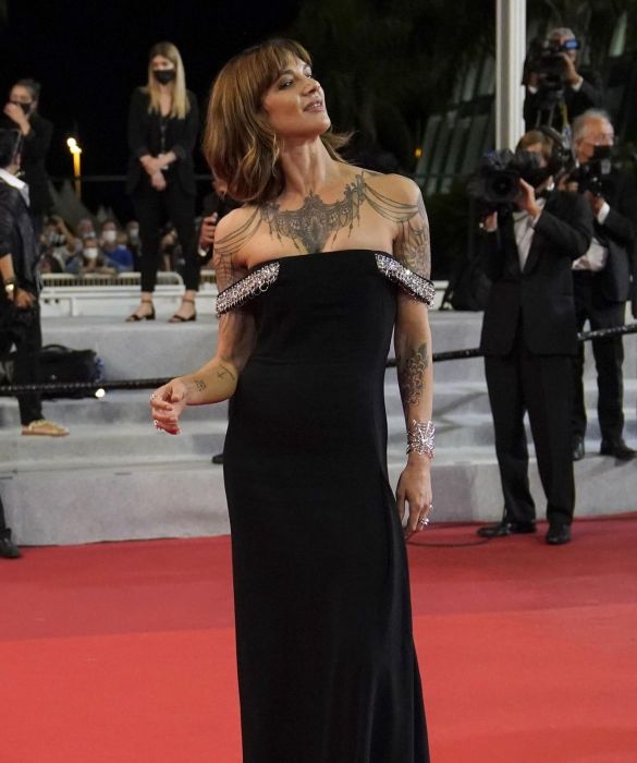 <p>Sul red carpet insieme a pap&agrave; Dario, per entrambi un look total black, firmato <strong>Givenchy</strong>. L&rsquo;attrice sfoggia un abito lungo cr&ecirc;pe de chine con spalline gioiello: una scelta da diva che, con un contrasto di gran classe, esalta i tatuaggi su decollet&eacute; e spalle di Asia.</p>
