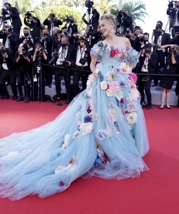 <p>Tanto sul tappeto rosso, quanto al party di <strong>AmfAR</strong>, la pi&ugrave; chic &egrave; senza dubbio lei. Sharon Stone, 63 primavere portate con un&rsquo;eleganza invidiabile, &egrave; un angelo azzurro, un sogno botticelliano, nel suo principesco abito azzurro, firmato <strong>Dolce&Gabbana</strong>. Tulle frusciante ricoperto da una cascata di maxi fiori ricamati, abbinato a orecchini pendenti con cuori sacri di <strong>Chopard</strong>. Lo sguardo magnetico enfatizzato da una semplice linea di matita nera.<br />
Il dettaglio di carattere: l&rsquo;inconfondibile <a href=